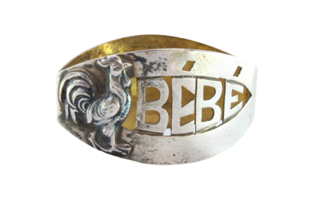 Argola de guardanapo em prata com galo em relevo e palavra "Bebé" recortada.